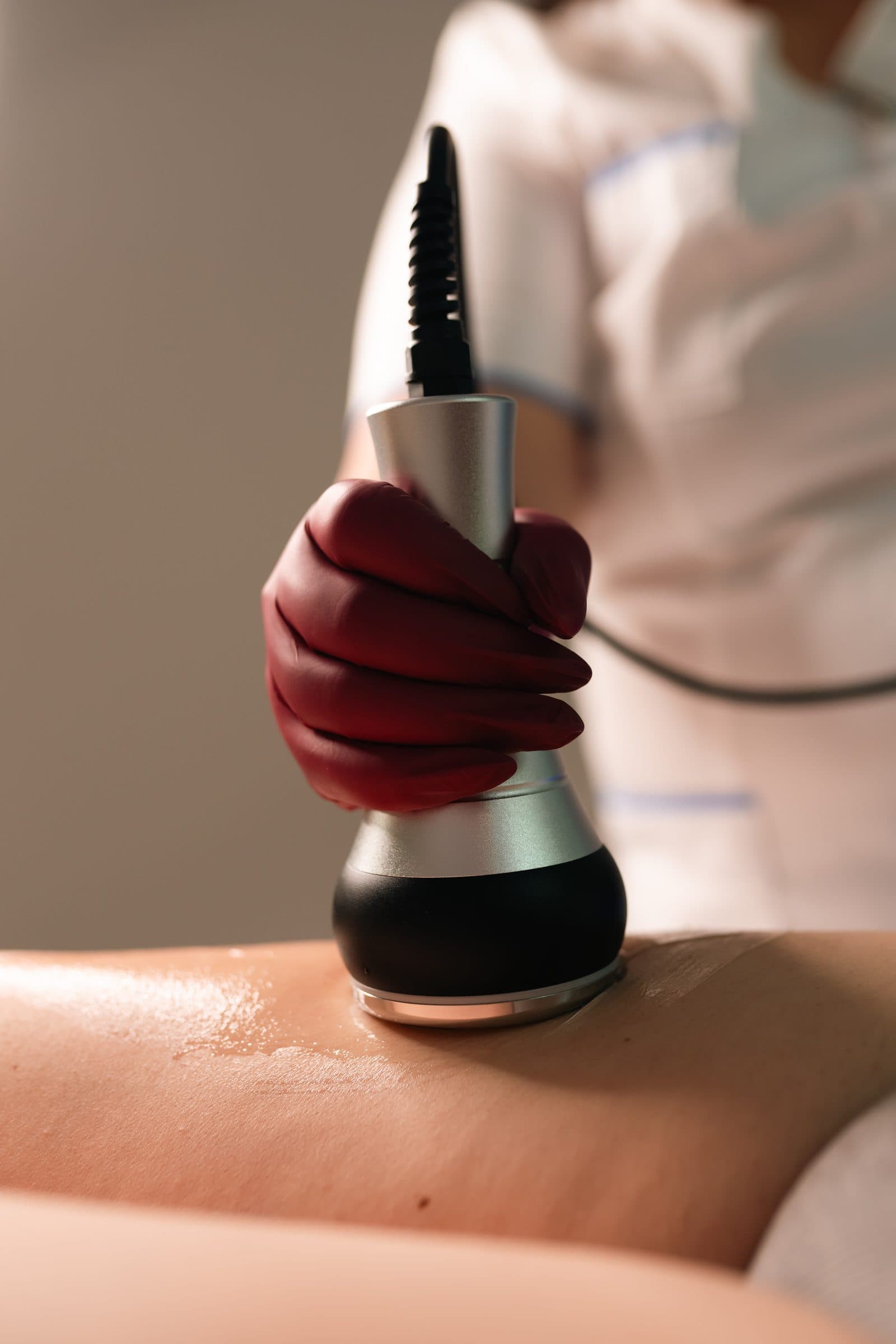 A therapist carrying out a treatment with a metal handpiece